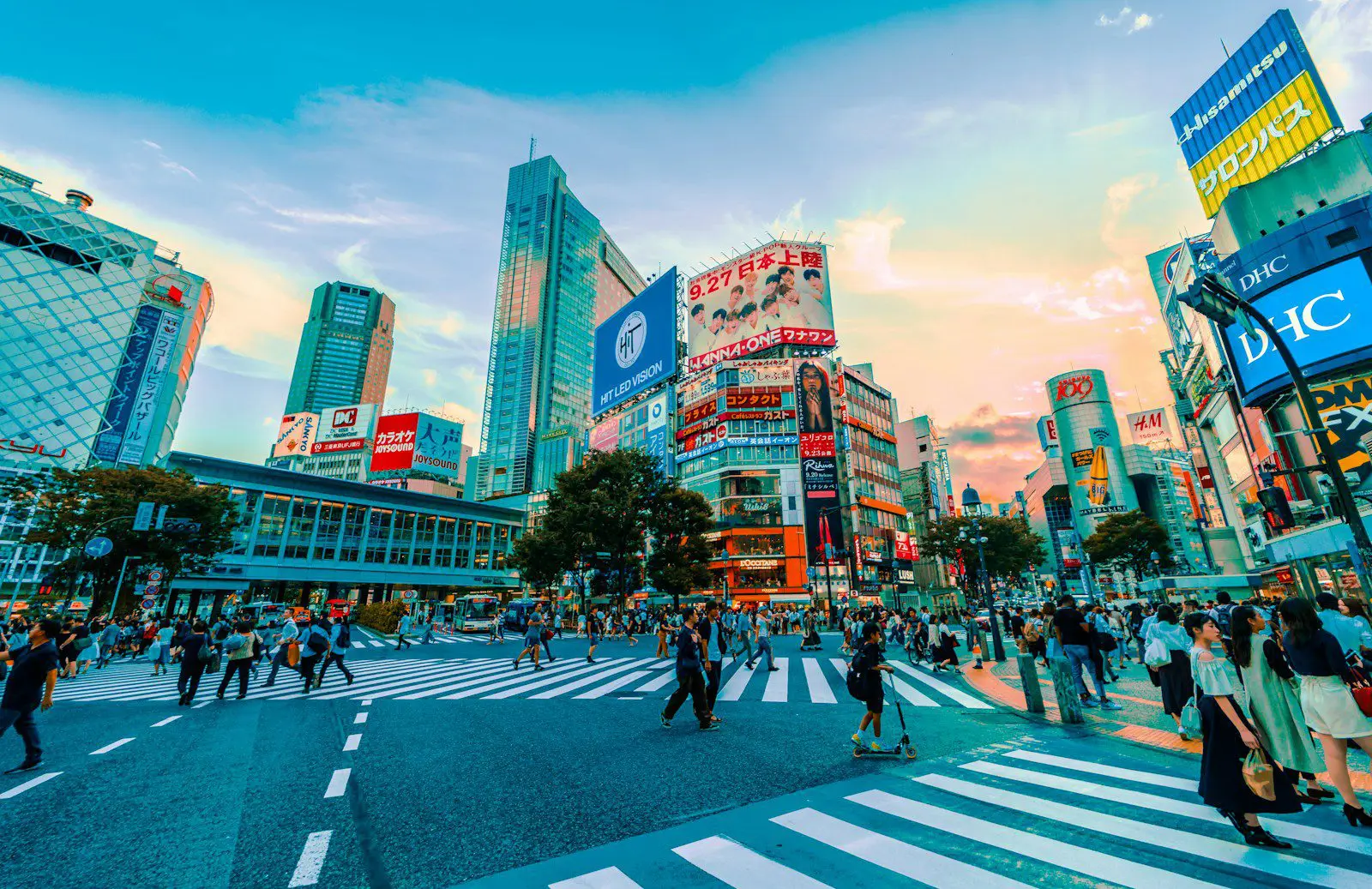 Shibuya Crossing in Tokyo at sunset showcasing Japan’s vibrant city life for expats and travelers.