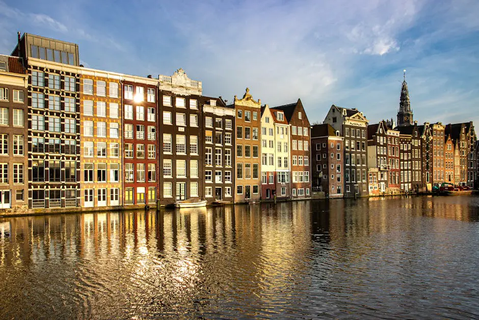 Amsterdam’s historic canal houses reflecting on calm water under a golden sunset, symbolizing Dutch culture and serene expat living.