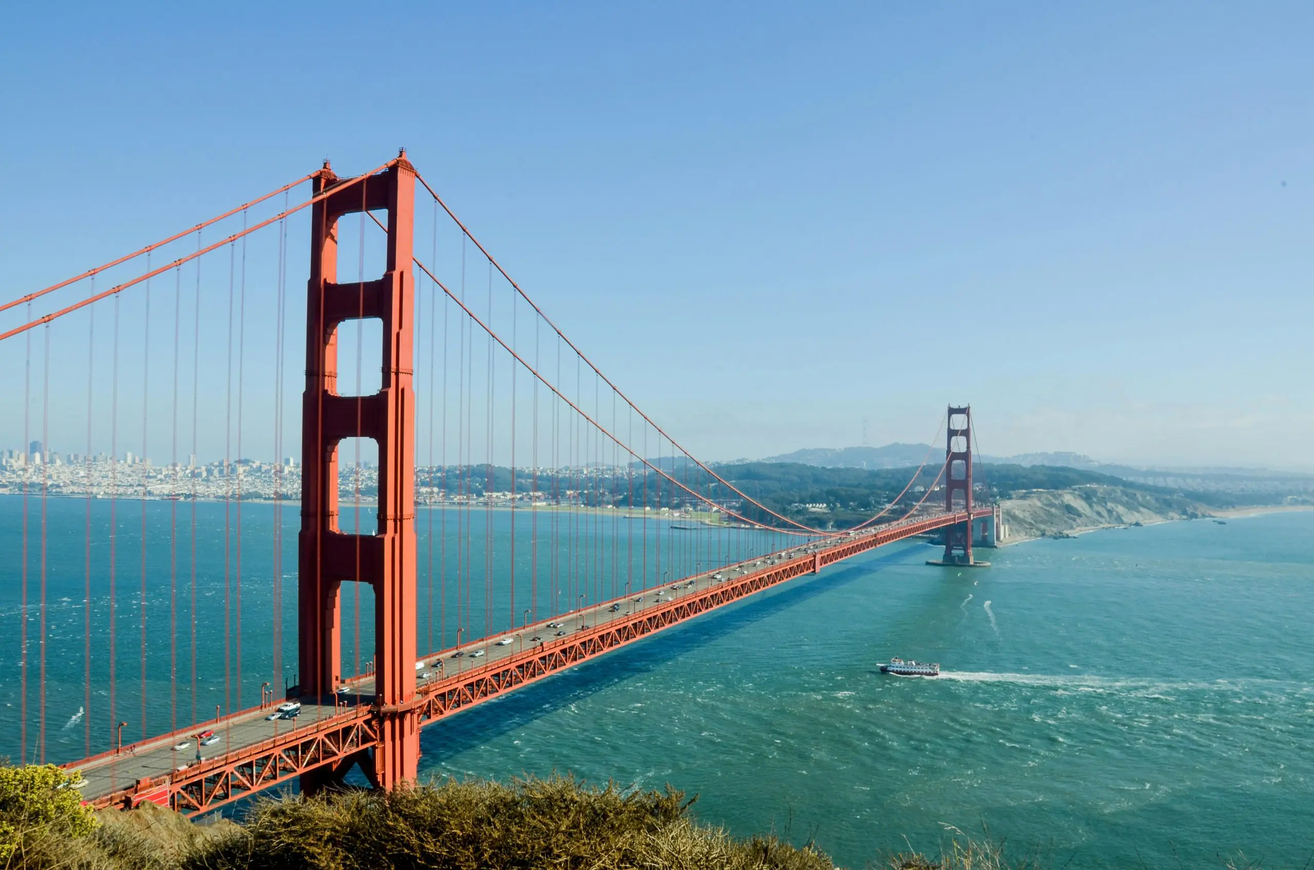 Golden Gate Bridge stretching across San Francisco Bay under clear blue skies, symbolizing travel and expat life in California.