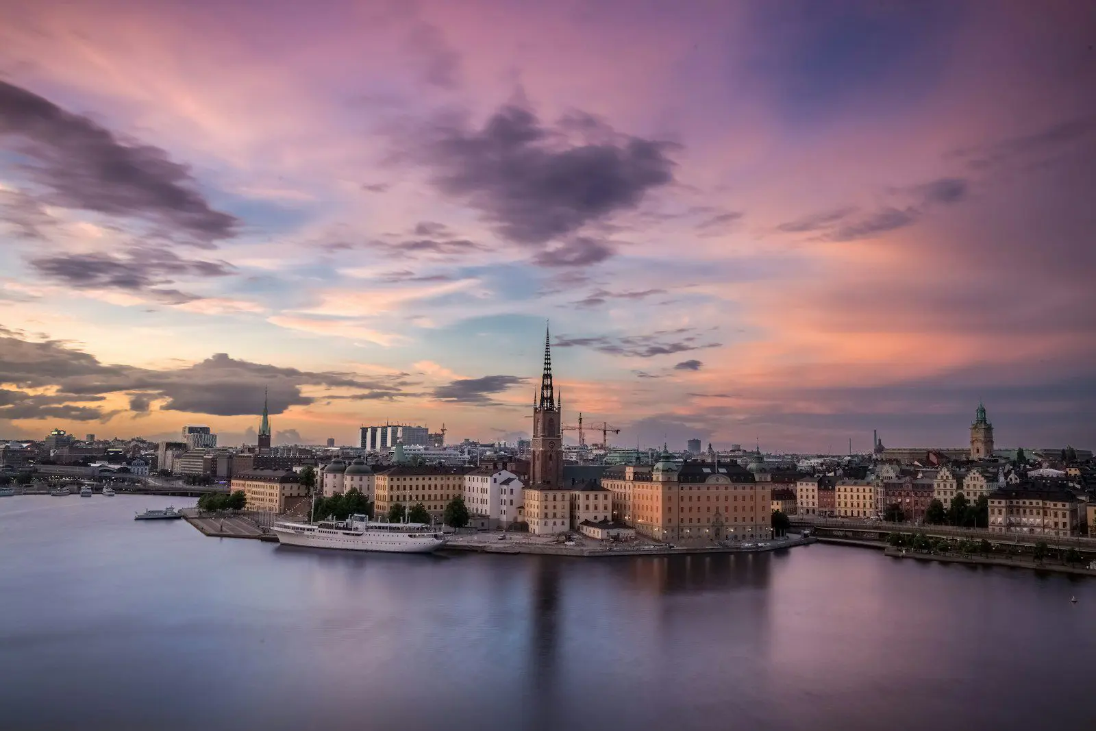 Photo by Raphael Andres Aerial view of Stockholm city skyline at sunset with waterfront and spires, highlighting Sweden’s urban beauty and expat lifestyle.
