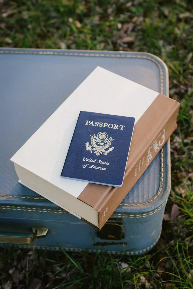 U.S. passport on suitcase and book, symbolizing international travel and visa process for expats
