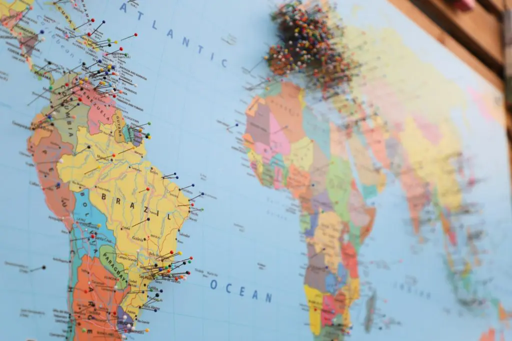 Photo by Leandro Barreto World map with pins representing expat destinations across continents for relocation and travel guides.