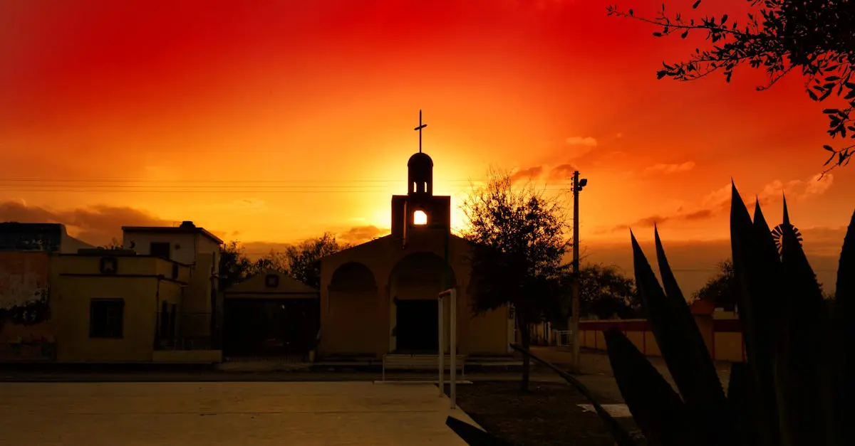 Silhouetted church with a cross against a dramatic sunset sky, showcasing vibrant colors and cultural architecture.