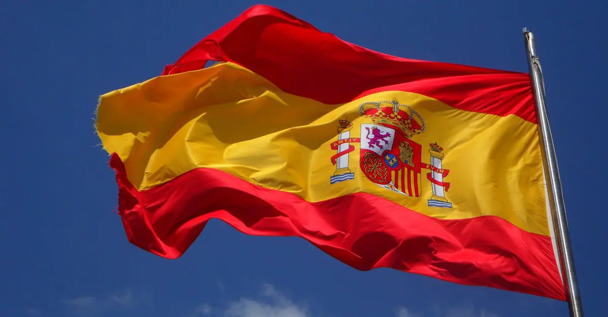 Spanish national flag waving in the wind against a bright blue sky, symbolizing Spain’s culture and identity.