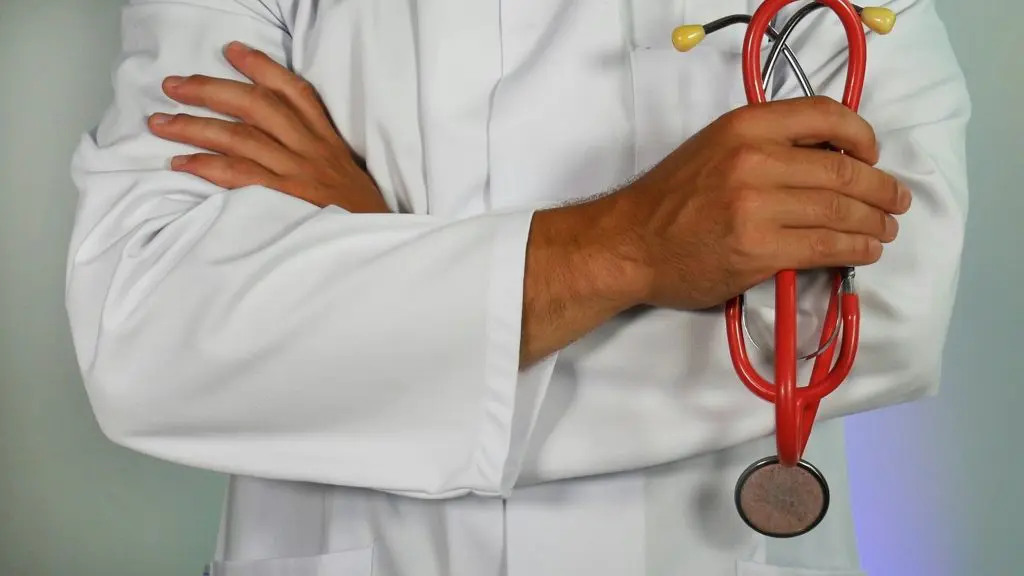 Doctor in a white coat holding a red stethoscope, symbolizing professional healthcare services and hospital care for expatriates.