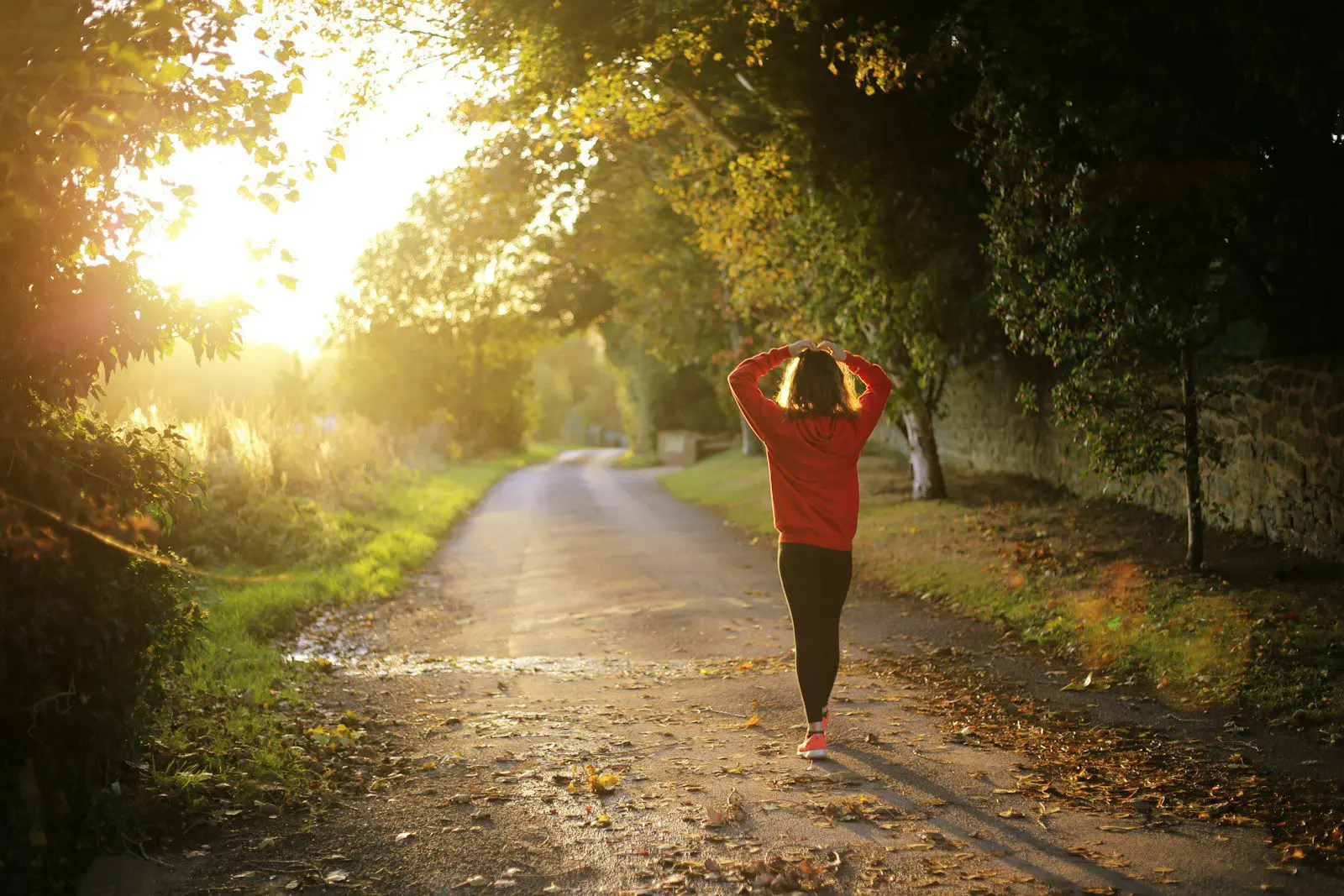 Photo by Emma Simpson Person walking on a peaceful country road at sunrise, symbolizing planning ahead and a healthy lifestyle for expats managing their insurance costs abroad.