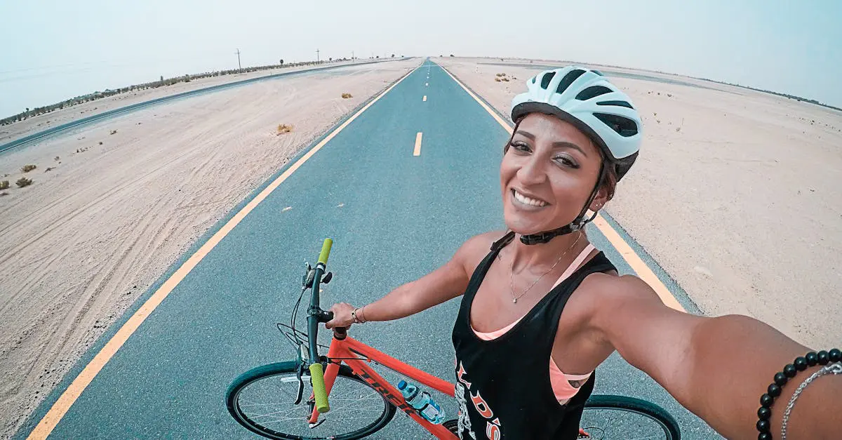 Smiling woman taking a selfie during a cycling workout on a desert road in Dubai, representing a healthy expat lifestyle.