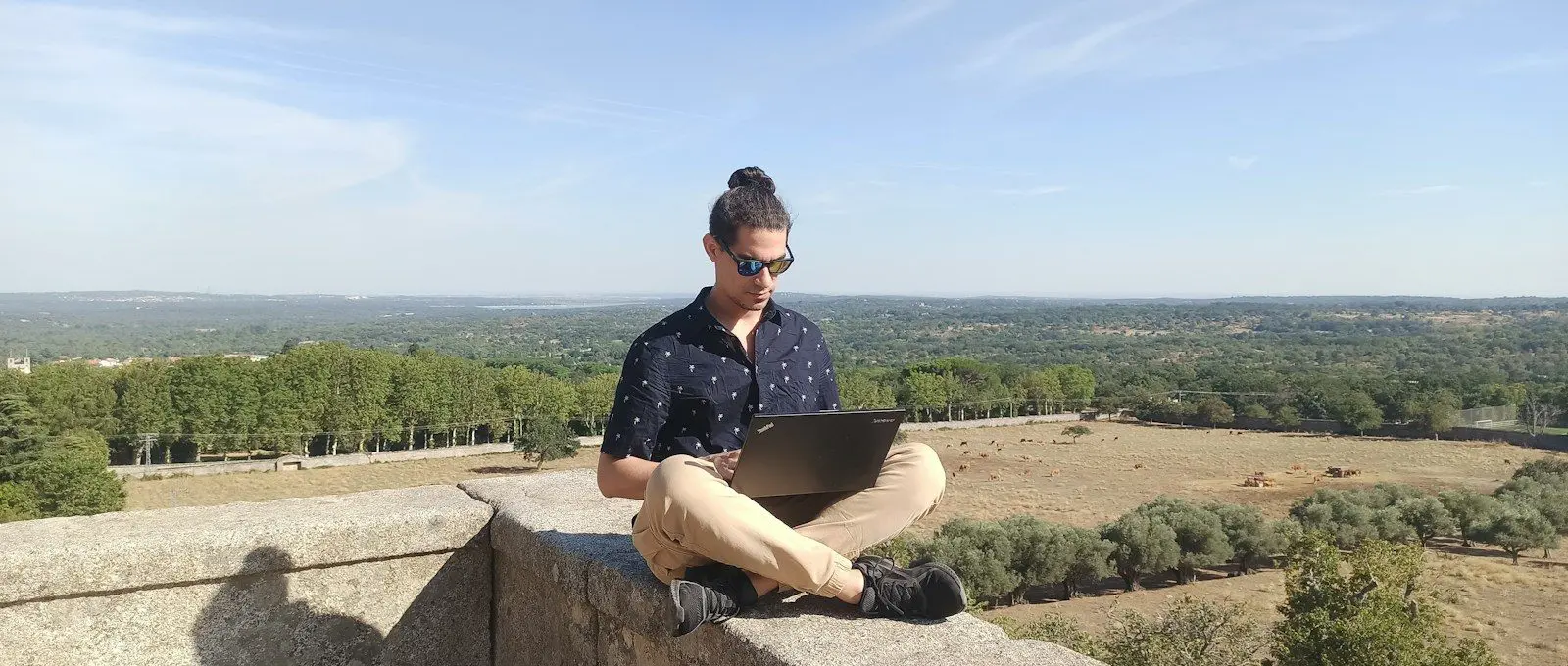 woman in black shirt sitting on gray concrete bench during daytime