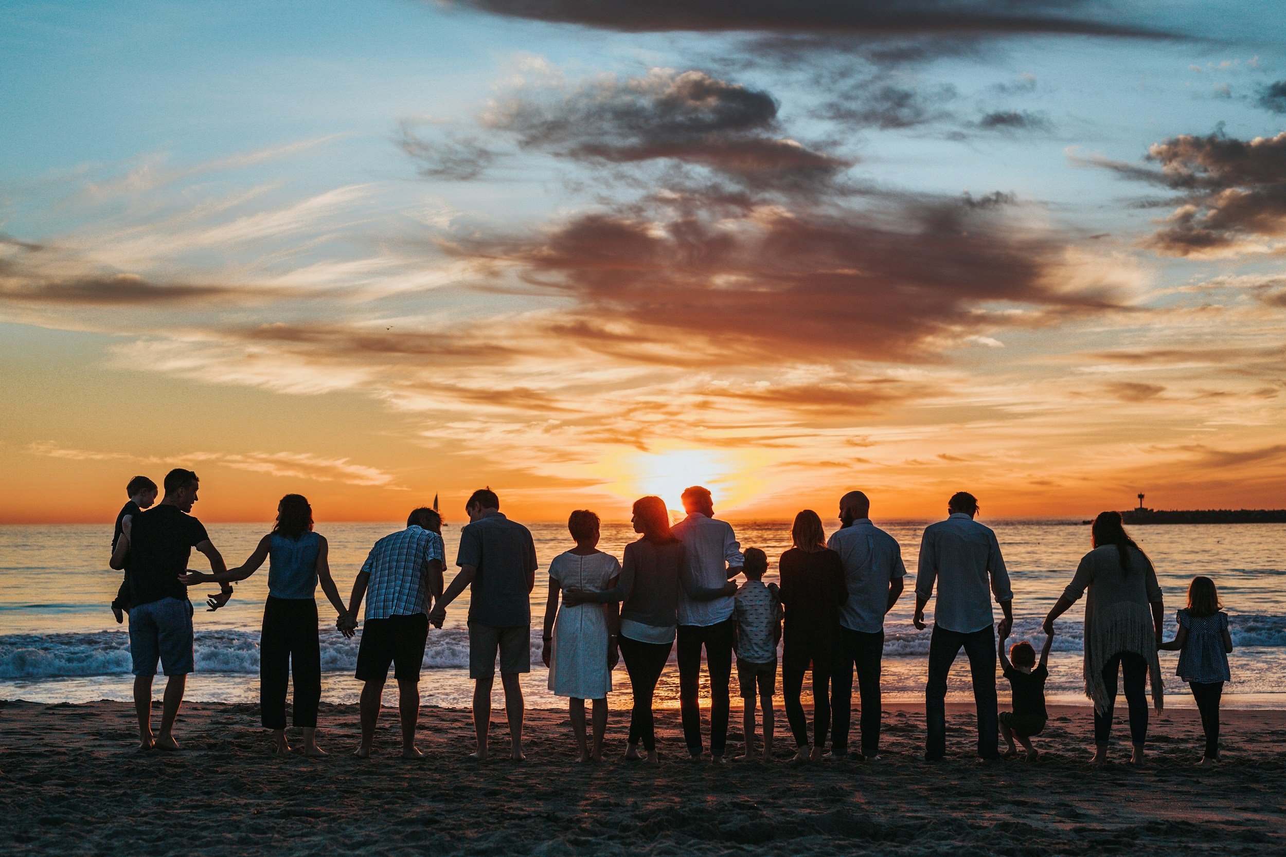 Happy expat family holding hands at sunset