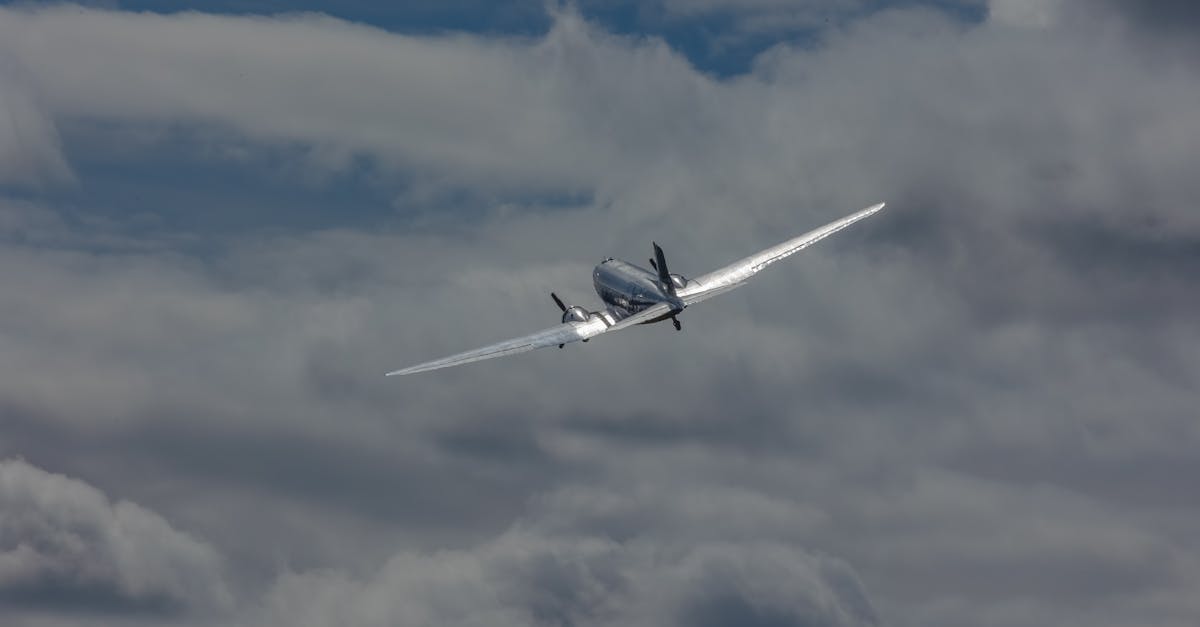 A classic aircraft flies gracefully amidst dramatic clouds, capturing the essence of aviation freedom.