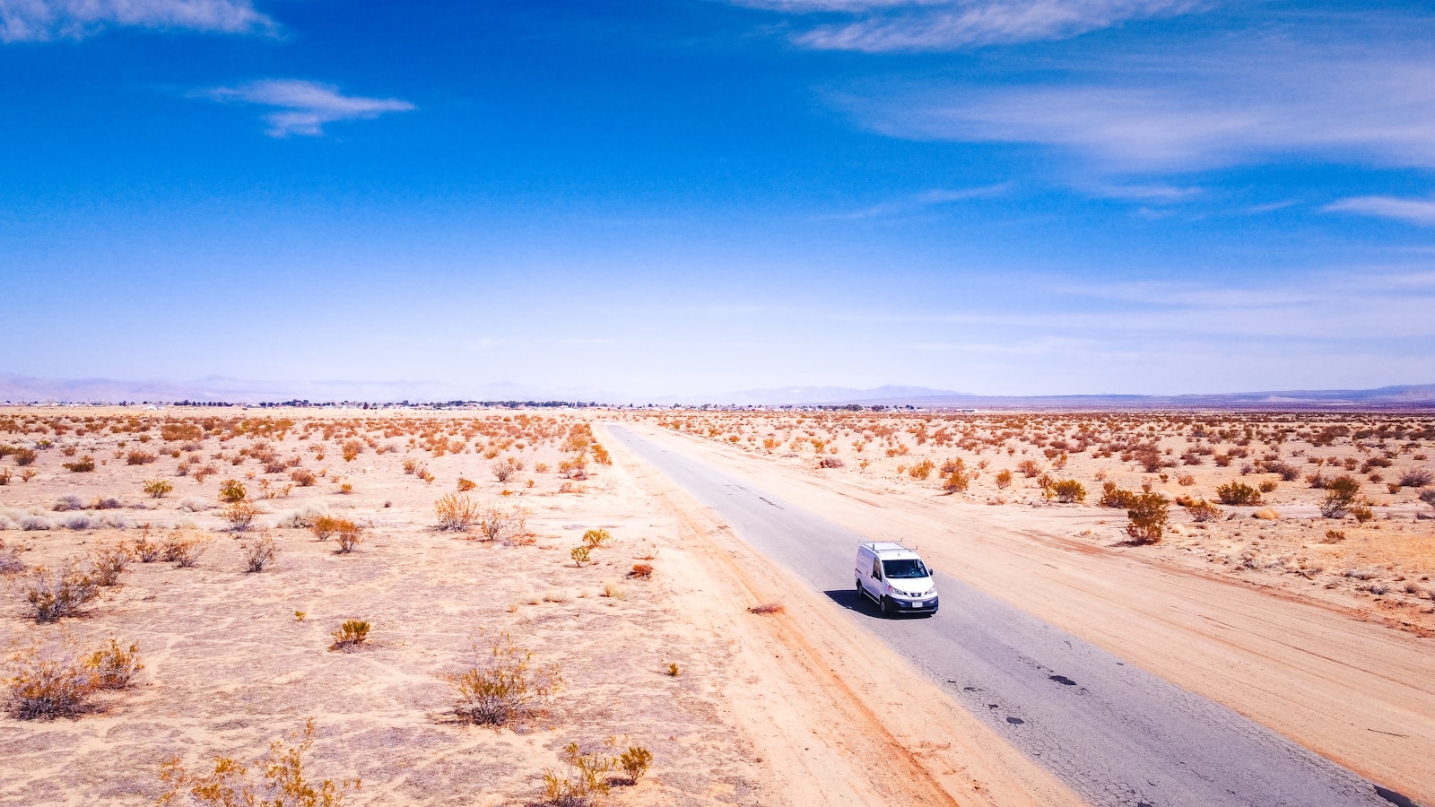 Photo by Brian Wangenheim white car on brown field under blue sky during daytime