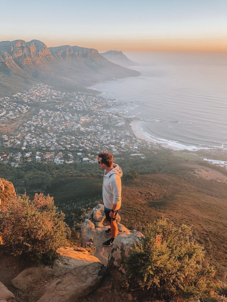 man standing on ledge overlooking town